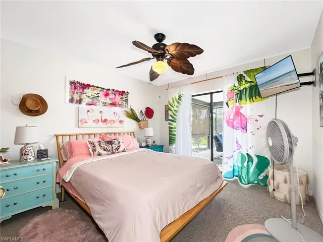 Carpeted bedroom with ceiling fan and access to exterior