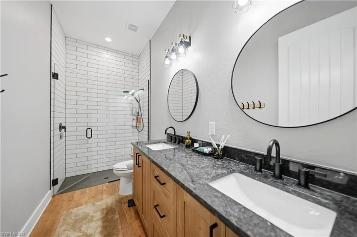 Double vanity featuring rectangular undermount sinks, stone countertops, and matte black fixtures