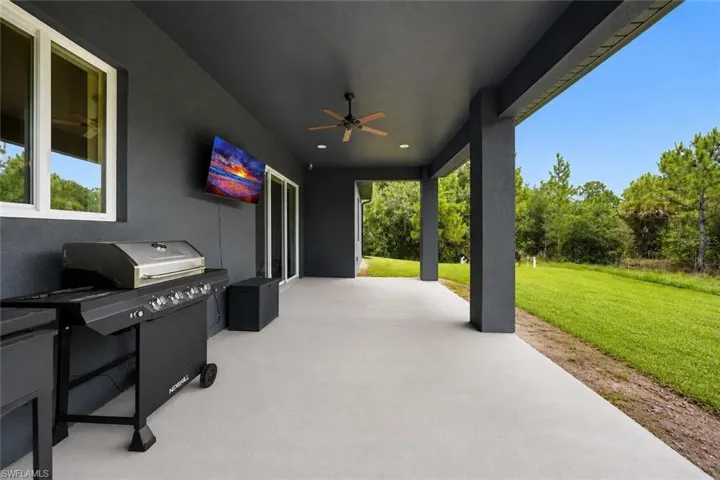 Expansive covered patio featuring a ceiling fan, recessed lighting, and direct outdoor access through multiple sliding glass doors