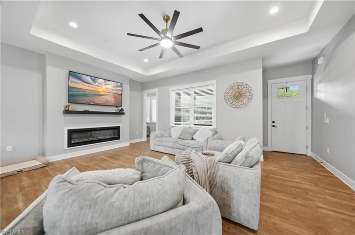 Open-concept living space featuring wood-finish flooring, a contemporary ceiling fan, and recessed lighting