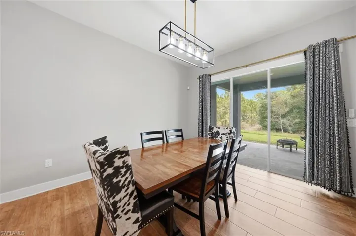 Dining area featuring wood-finish flooring and a contemporary linear chandelier