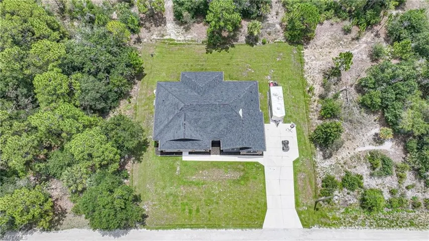 Single-story residence featuring a dark shingle roof, light-toned exterior walls, and a concrete driveway