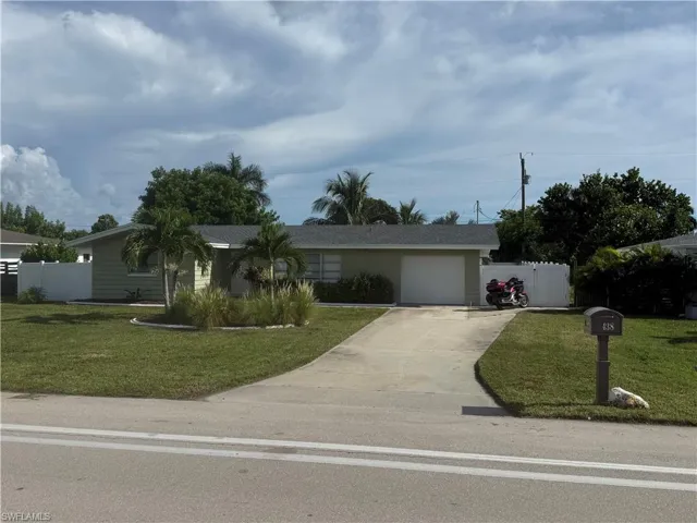 Single-story residence with a light green exterior, a gray shingle roof, and an attached garage with a white door