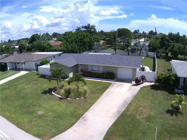 Single-story residence with a light-colored exterior and a dark shingle roof