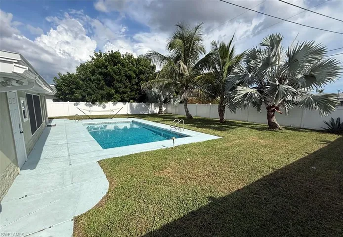 Rectangular inground swimming pool with integrated steps, surrounded by a concrete pool deck