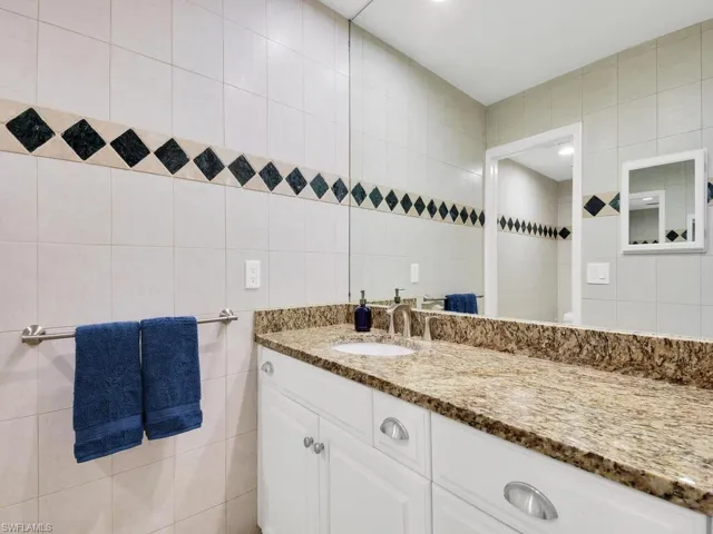 Bathroom with vanity and tile walls
