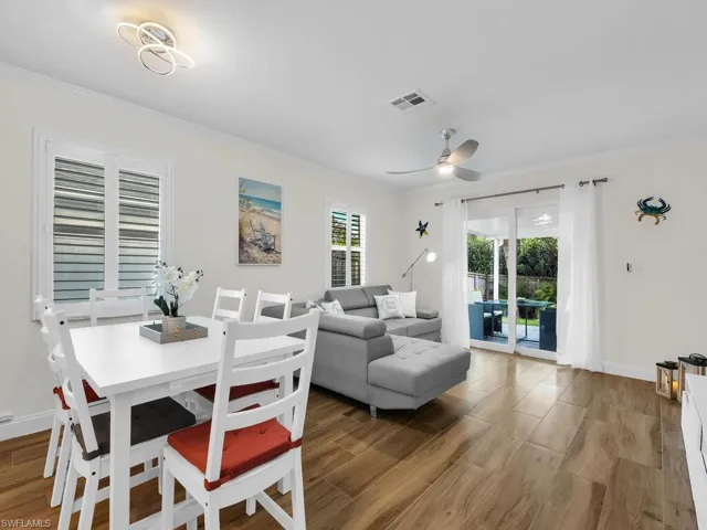 Dining area with ornamental molding, light wood-type flooring, and ceiling fan