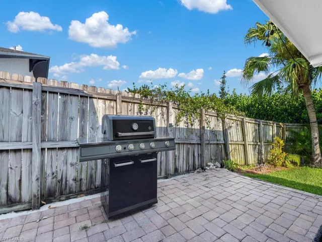 Fenced backyard with a patio and a grill