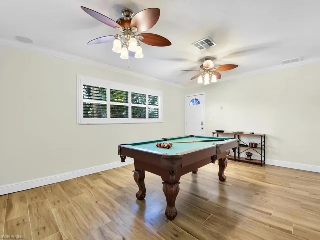 Game room featuring pool table, ornamental molding, light wood finished floors, and ceiling fan