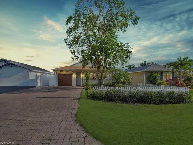 Ranch-style house with decorative driveway and a garage