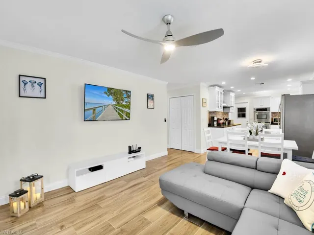 Living room with crown molding, light wood-style floors, recessed lighting, and a ceiling fan