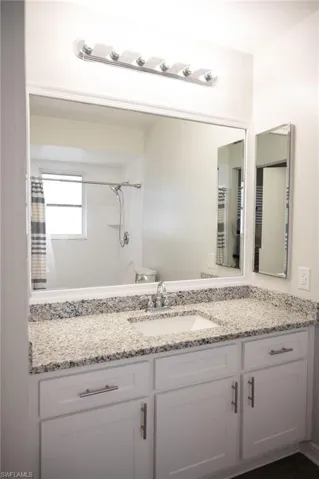 Full bathroom with vanity and curtained shower