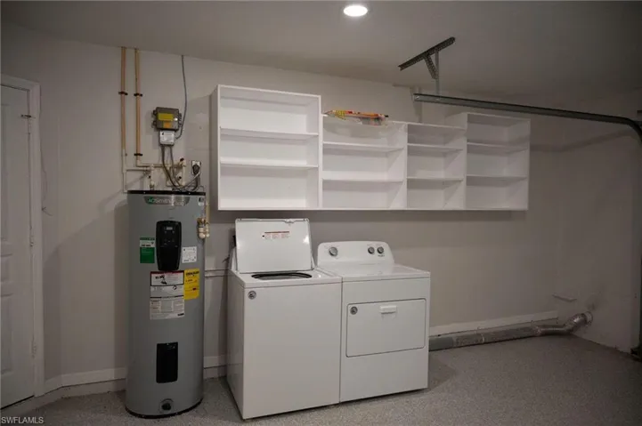 Laundry area featuring electric water heater and washer and clothes dryer