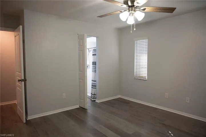 Unfurnished bedroom with dark wood-style flooring and ceiling fan