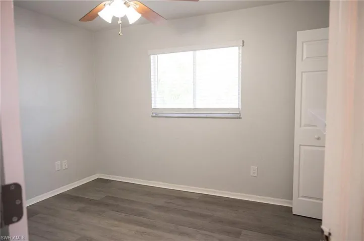 Empty room featuring dark wood-style floors and ceiling fan