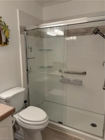 Bathroom featuring vanity, a shower stall, and light tile patterned flooring