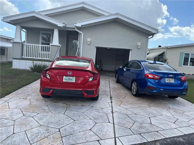 View of front of house featuring concrete driveway, an attached garage, and a porch