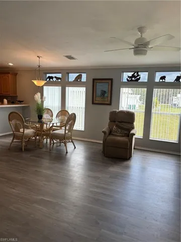 Dining area with healthy amount of natural light, a ceiling fan, and dark wood-style flooring