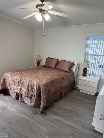 Bedroom featuring ornamental molding, wood finished floors, and a ceiling fan