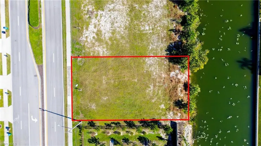 Aerial view of property and surrounding area featuring a large body of water and property parcel outlined