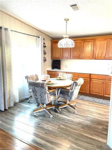 Dining area featuring a textured ceiling and light wood-style floors