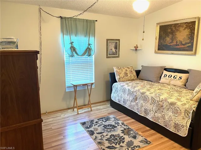 Bedroom with a textured ceiling and light wood-style flooring