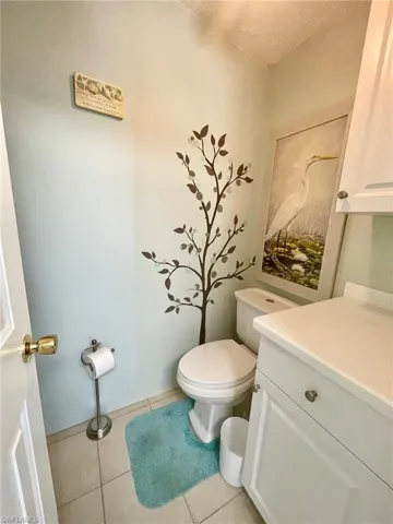 Bathroom with light tile patterned floors, vanity, and a textured ceiling