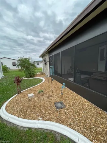 View of side of home with a sunroom and a yard