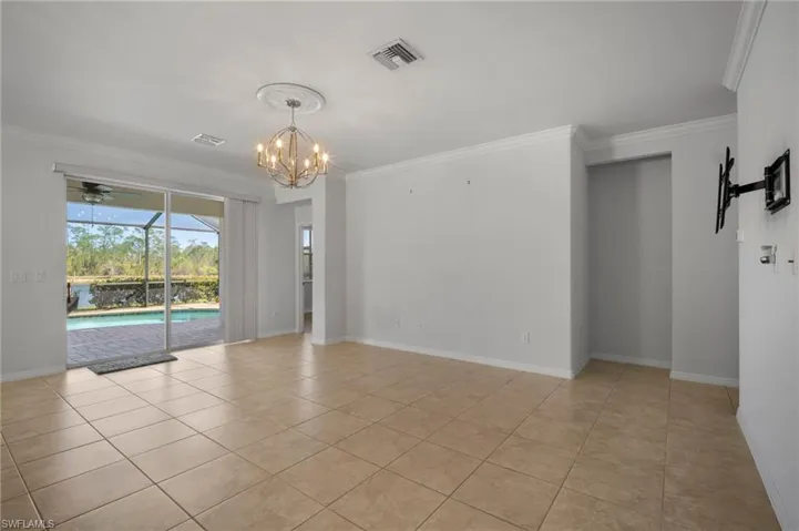 Unfurnished room with light tile patterned floors, crown molding, visible vents, and a sunroom