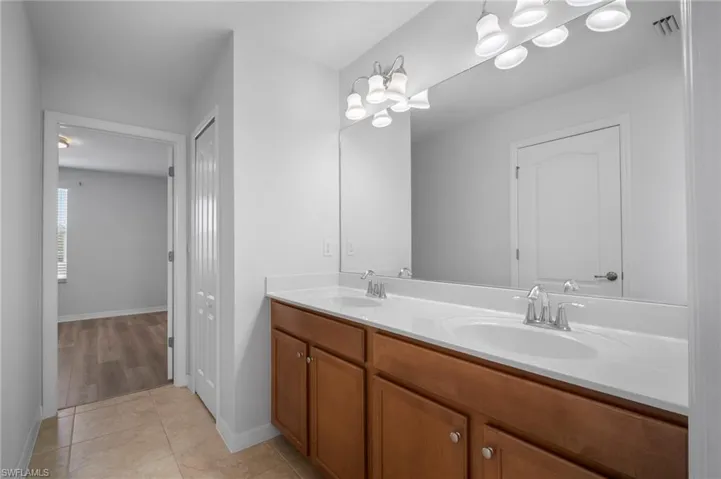 Bathroom featuring a closet, tile patterned flooring, and a sink