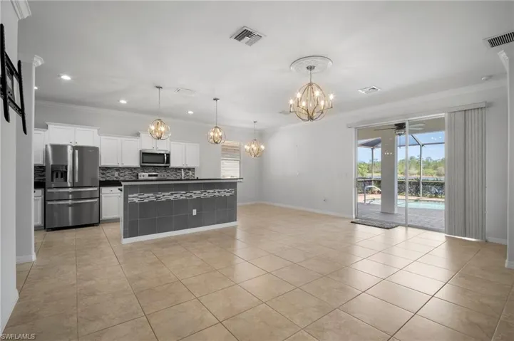 Kitchen with visible vents, appliances with stainless steel finishes, white cabinetry, and pendant lighting