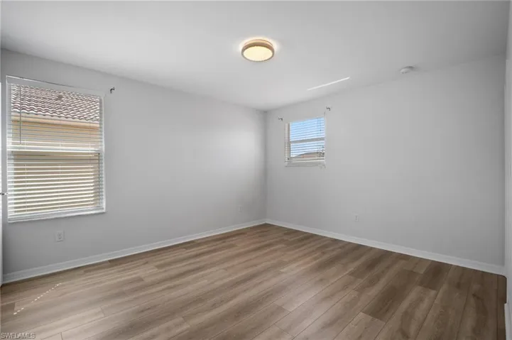 Spare room featuring light wood-style flooring and baseboards