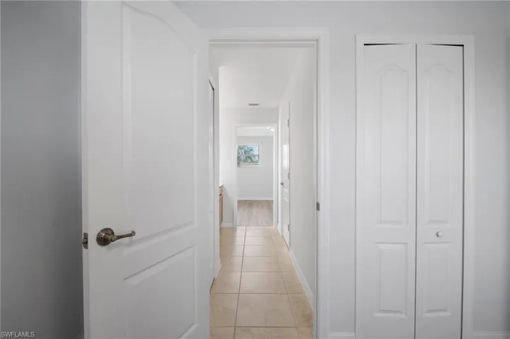 Corridor with light tile patterned floors and baseboards