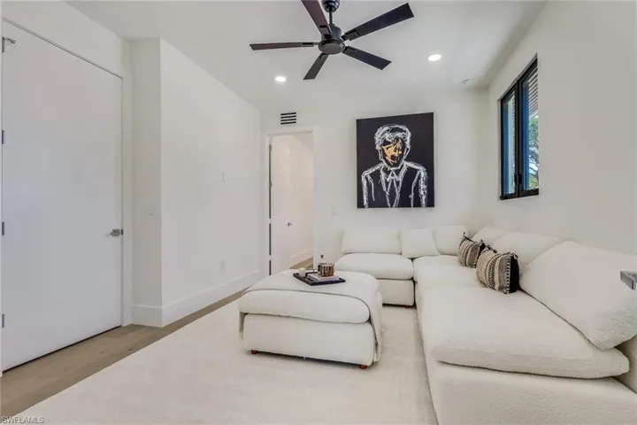 Living room with light wood-style floors, a ceiling fan, and recessed lighting