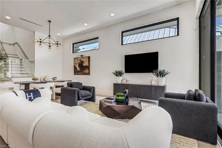 Living room featuring stairs and suspended lighting