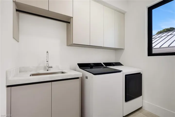 Laundry room with cabinet space, washer and clothes dryer, and light wood finished floors