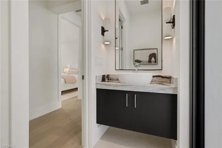 Bathroom featuring vanity, ensuite bath, and light wood-style flooring