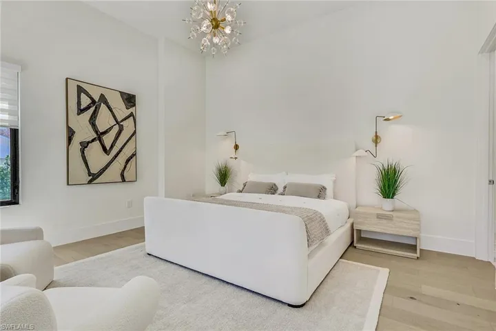 Bedroom with light wood-type flooring and a chandelier