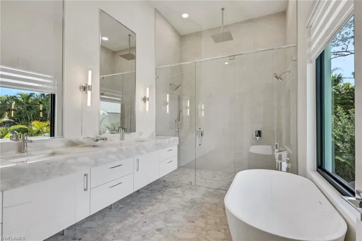 Full bathroom with a freestanding tub, double vanity, and a shower stall