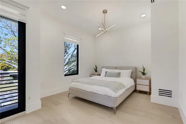 Bedroom featuring light wood finished floors and a chandelier