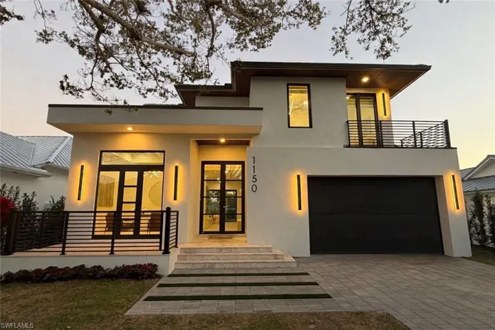 Contemporary house featuring french doors, stucco siding, decorative driveway, a garage, and a porch