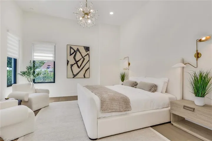 Bedroom with suspended lighting and wood finished floors