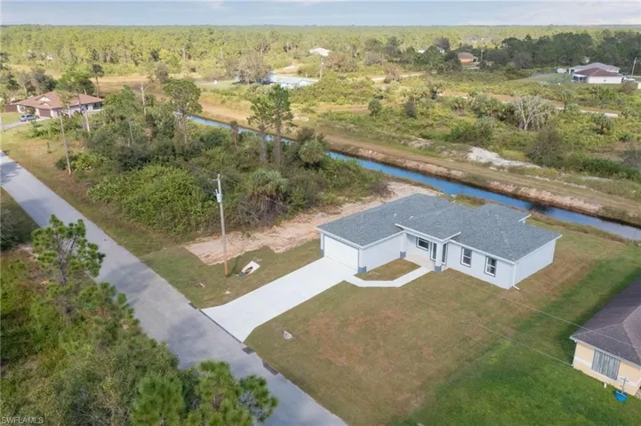 Birds eye view of property with a water view