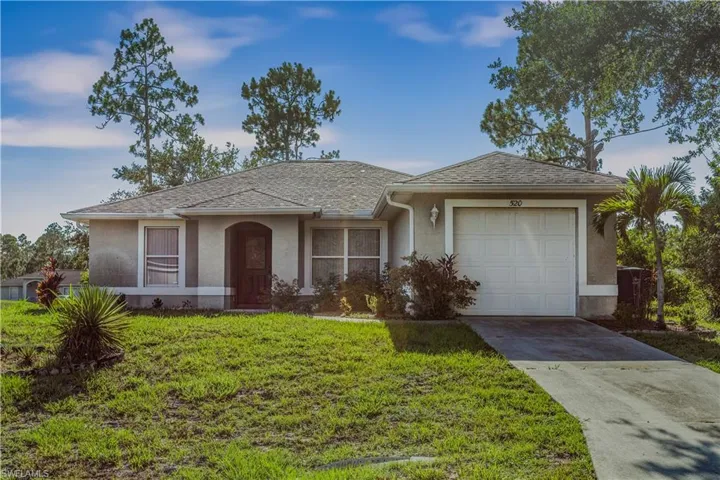 Single story home featuring a front yard and a garage