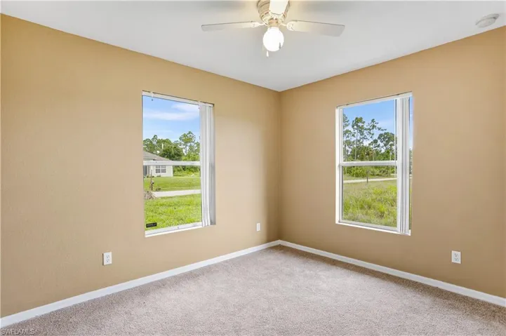 Carpeted spare room with ceiling fan