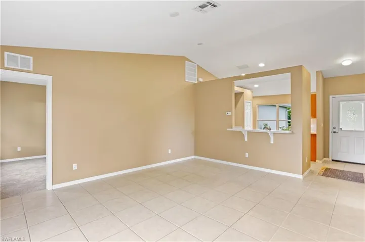 Empty room featuring lofted ceiling and light carpet
