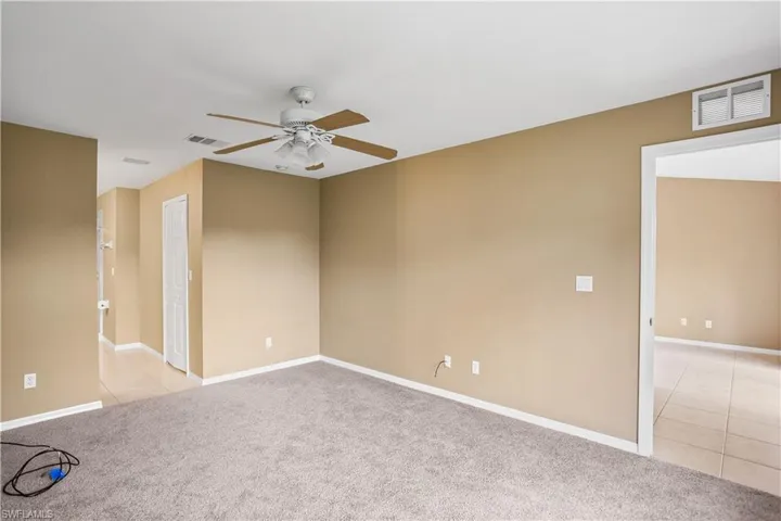 Empty room featuring ceiling fan and light tile floors