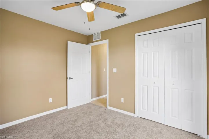 Unfurnished bedroom with a closet, ceiling fan, and carpet floors