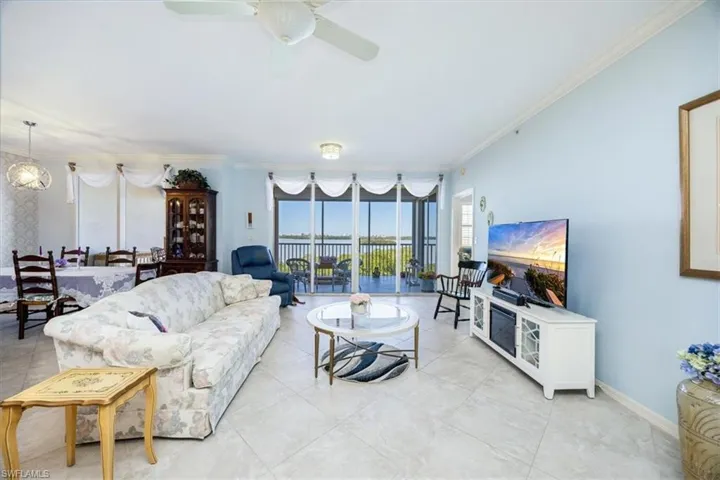 Living room with ceiling fan and ornamental molding