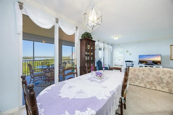 Dining space featuring a chandelier, light tile patterned floors, and ornamental molding
